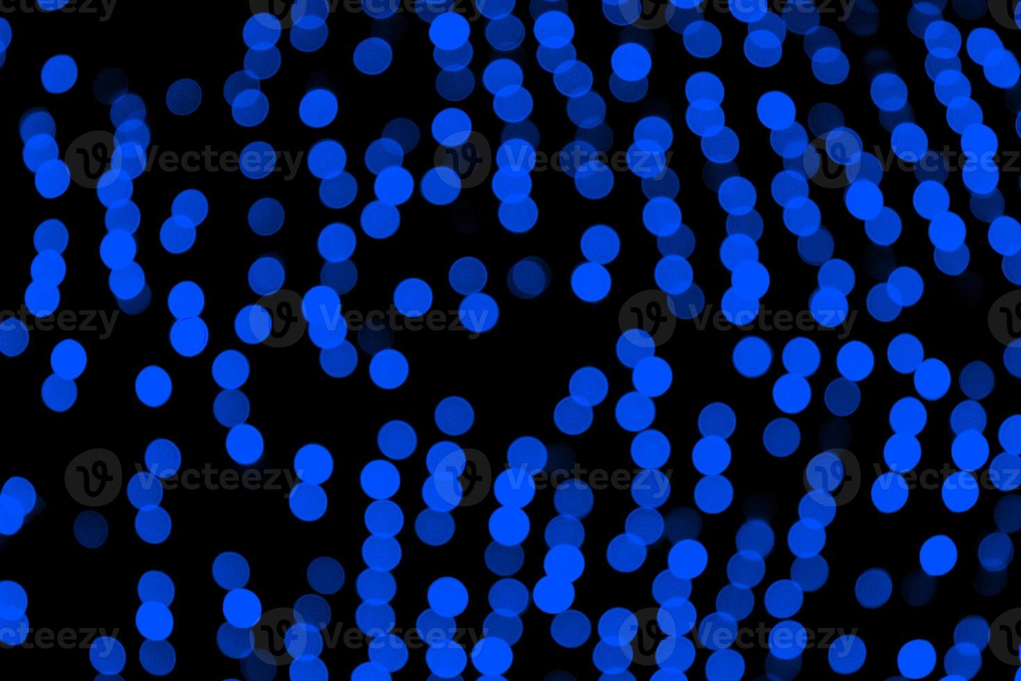 Unfocused abstract dark blue bokeh on black background. defocused and blurred many round light photo