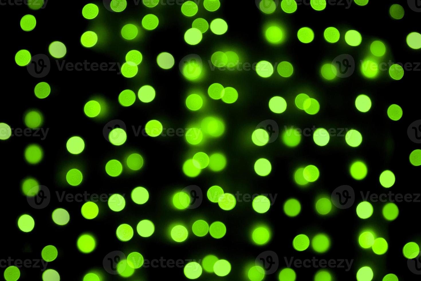 Unfocused abstract colourful bokeh black background. defocused and blurred many round green light photo