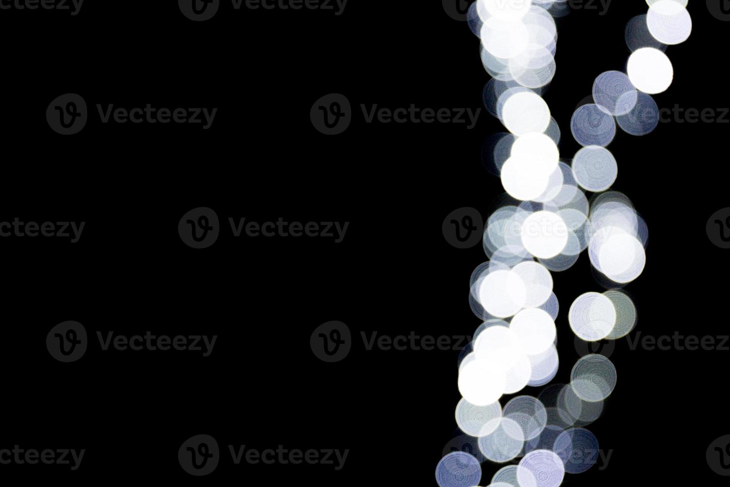 Abstract bokeh of white city lights on black background. defocused and blurred many round light photo
