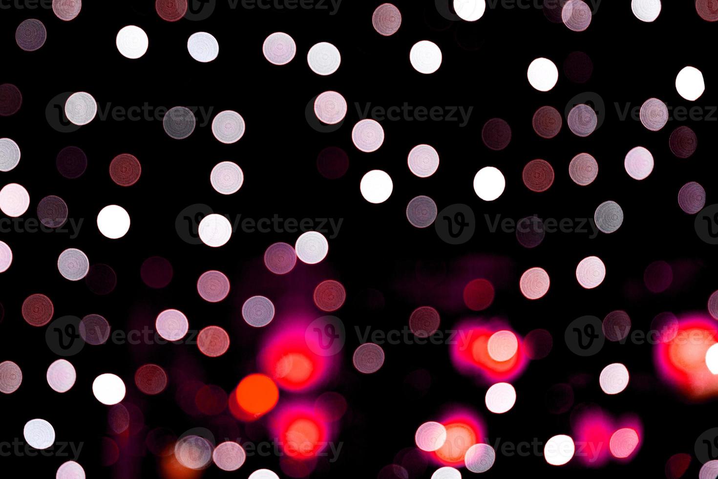 Unfocused abstract colourful bokeh on black background. defocused and blurred many round light photo