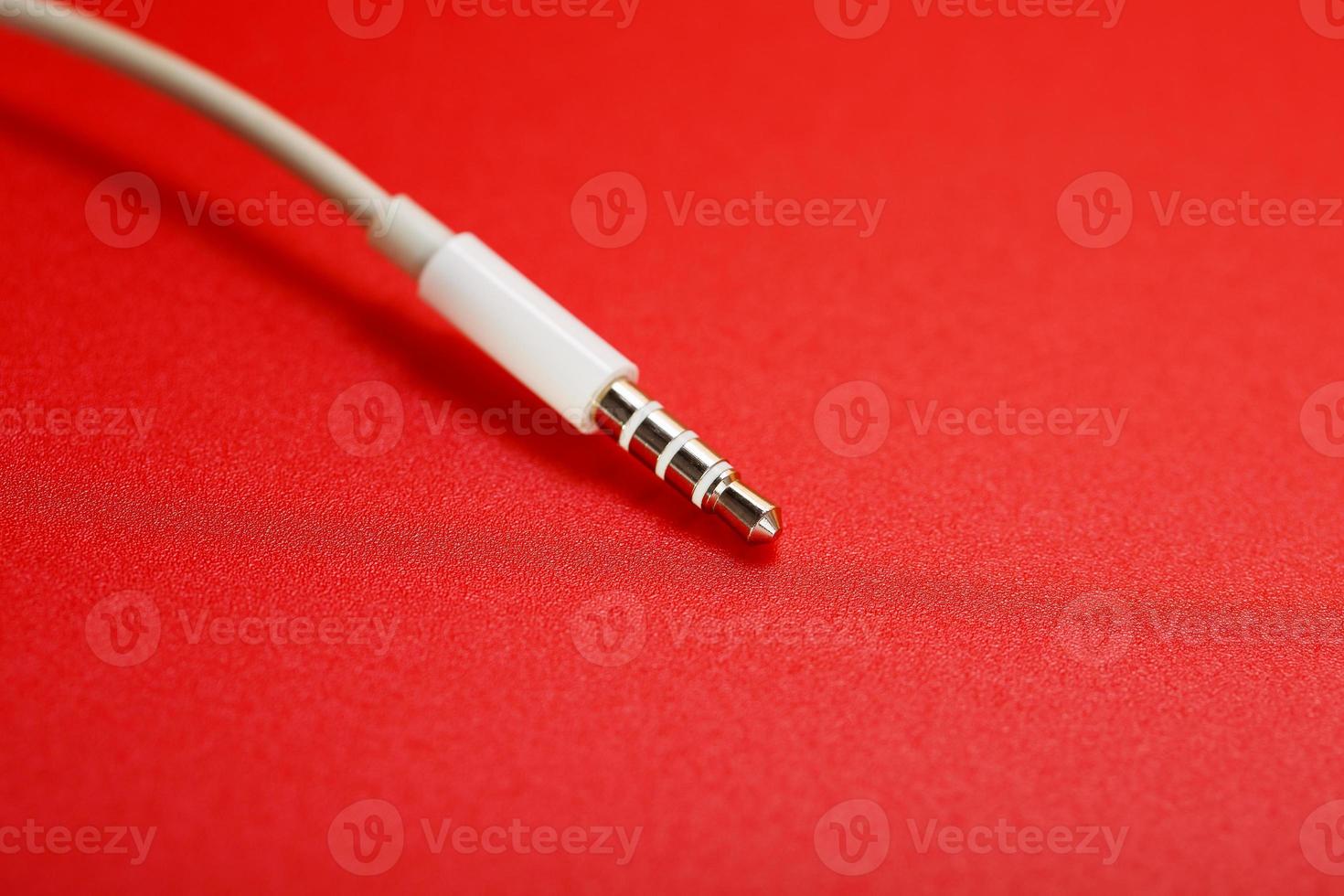 White connector AUX white cable on a red background photo