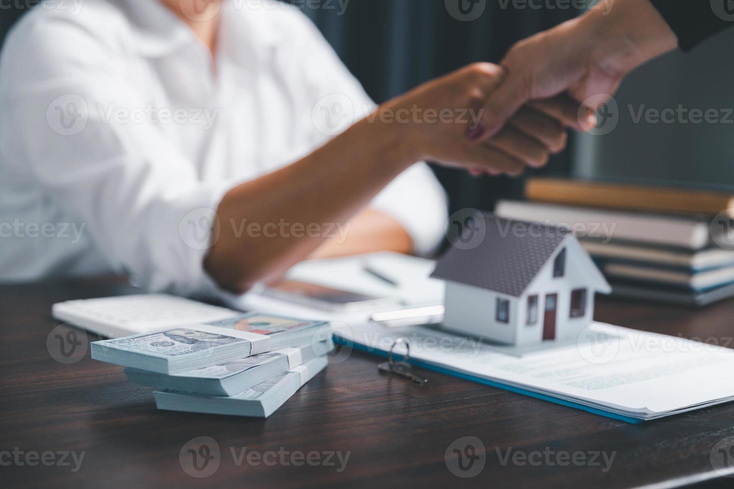 Real estate agents offer contracts to purchase or rent residential. Business person hands holding home model, small building red house. Mortgage property insurance moving home and real estate concept photo