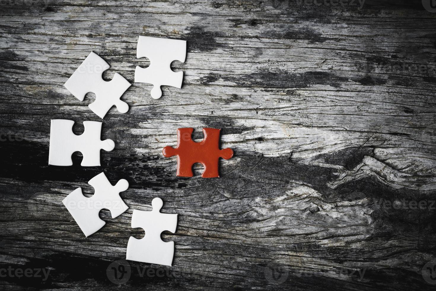 White details of jigsaw puzzle piece on wooden background. Concept of working together as a business team. The idea of getting involved, working for success. photo