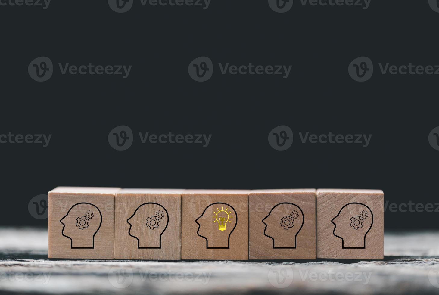 Knowledge and education concept. Concept creative idea and innovation. Hand choose wooden cube block with head human symbol and light bulb icon. Learning with smart technology. photo