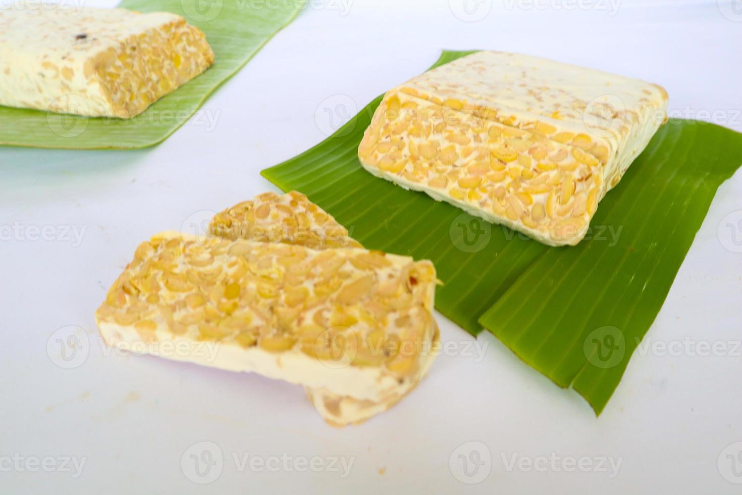 Raw tempeh or tempe. tempeh slices in white background. raw soybean seeds. Tempe is a traditional Indonesian food made from fermented soybeans. photo