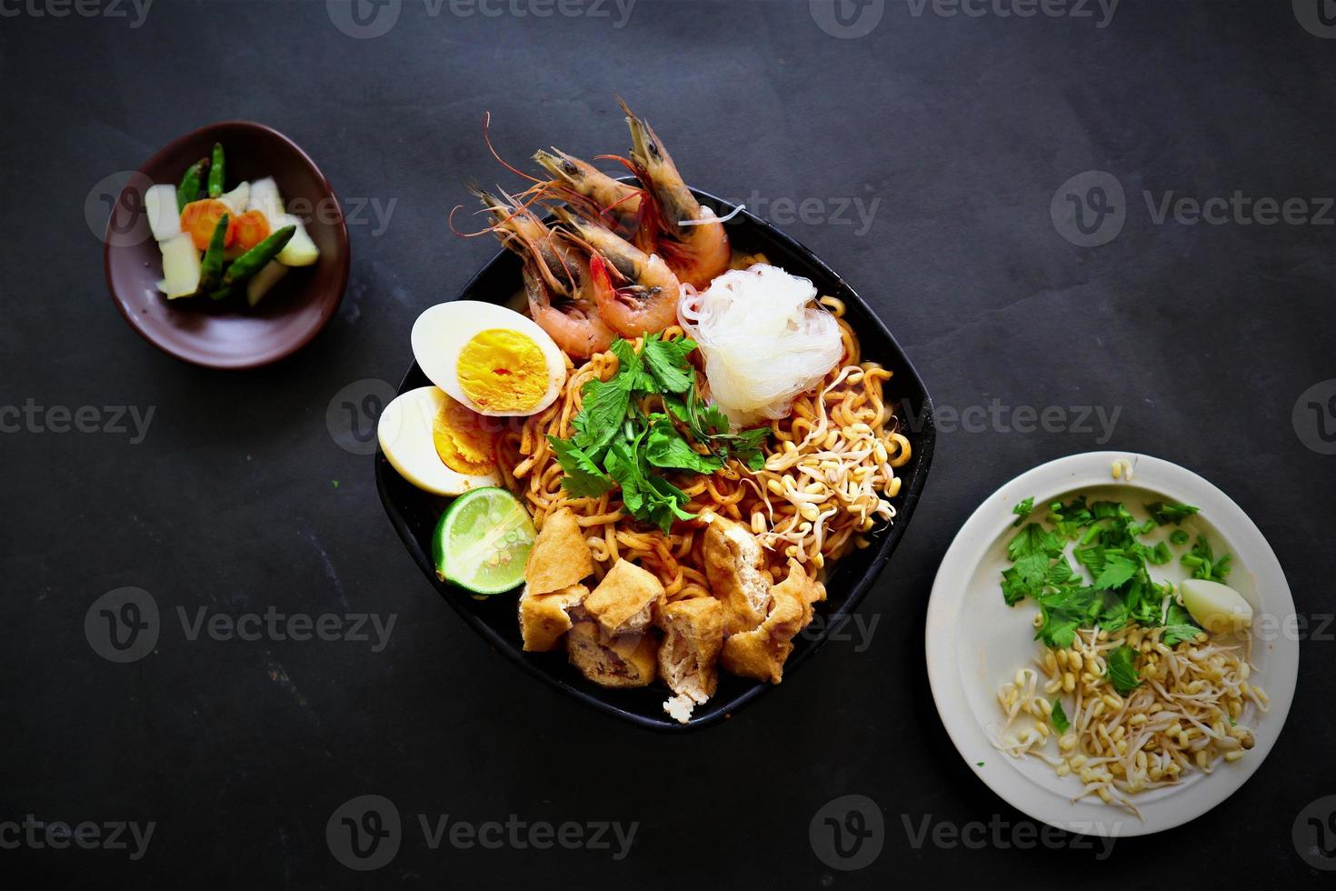 laksa, laksa curry made from vermicelli, noodles, bean sprouts, egg, tofu lime, and shrimp with a spicy soup sauce that is rich in spices. laksa served on bowl, isolated on white background. photo