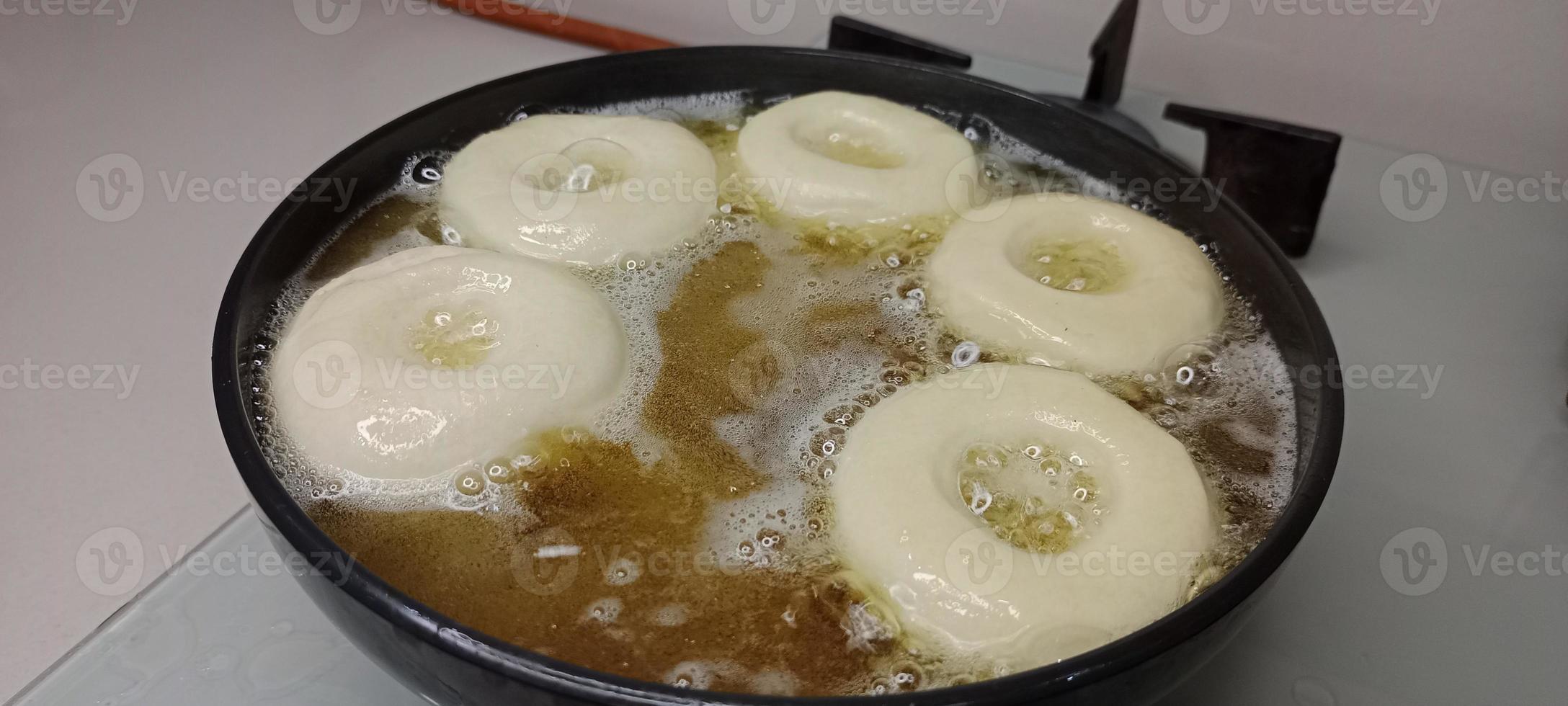 rosquillas variadas con glaseado de chocolate, glaseado rosa y rosquillas. donas en mano o bandeja foto