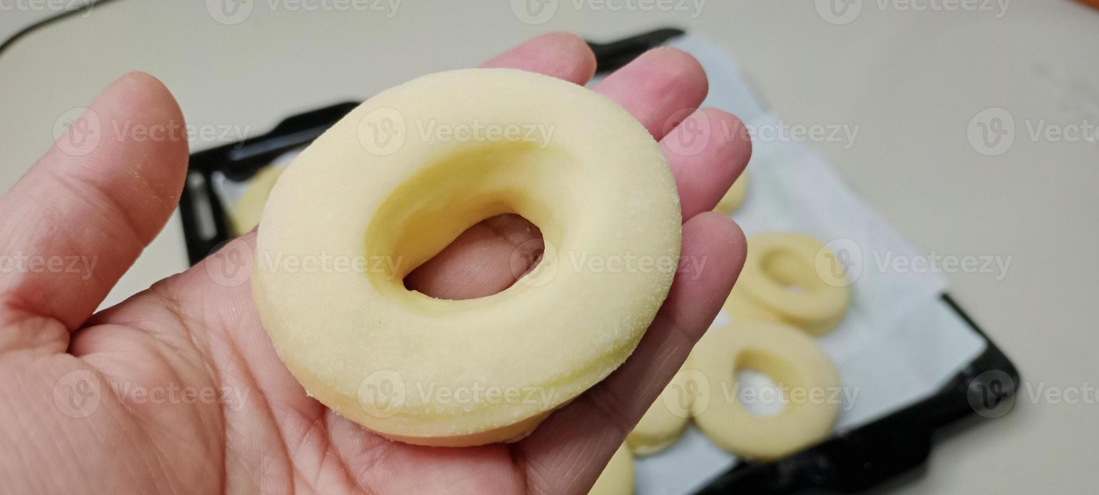 assorted donuts with chocolate frosted, pink glazed and sprinkles donuts. Donuts in hand or tray photo