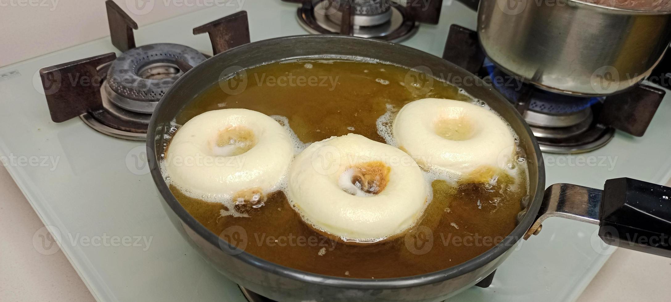 rosquillas variadas con glaseado de chocolate, glaseado rosa y rosquillas. donas en mano o bandeja foto