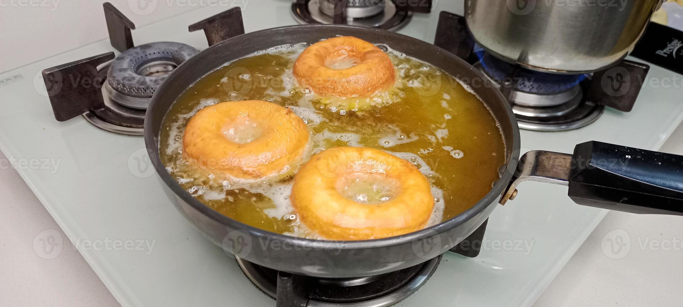 rosquillas variadas con glaseado de chocolate, glaseado rosa y rosquillas. donas en mano o bandeja foto