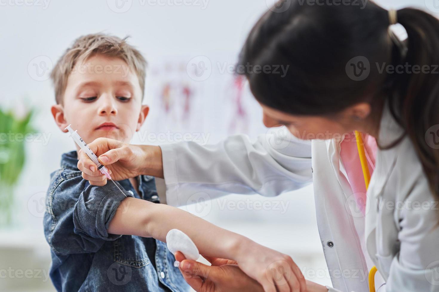 Little boy being vaccinated by pediatrician photo