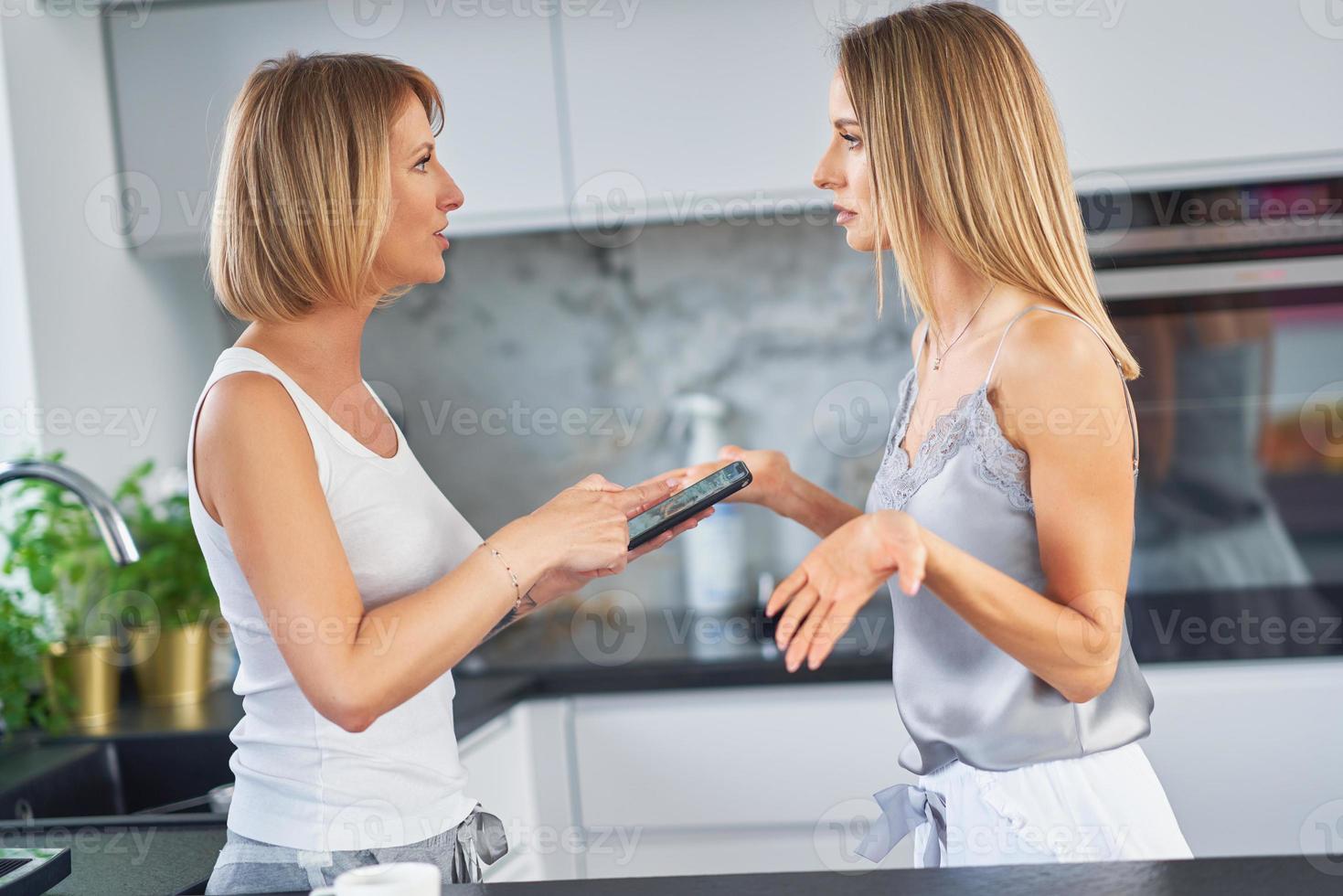 Nice two adult girls in the housethe are arguing with cell phone photo