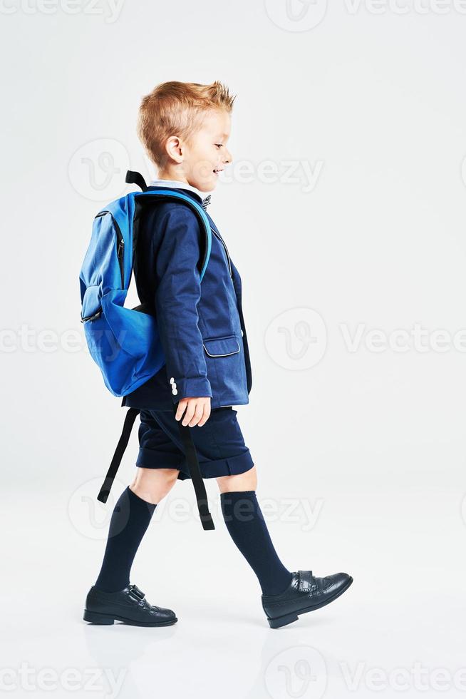 Portrait of a boy ready to school isolated on white photo