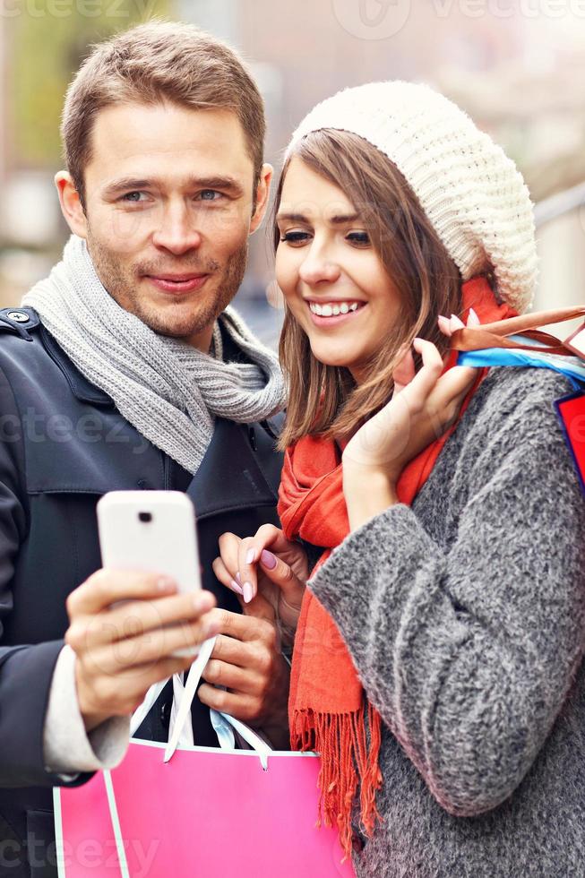Couple shopping in the city with smartphone photo