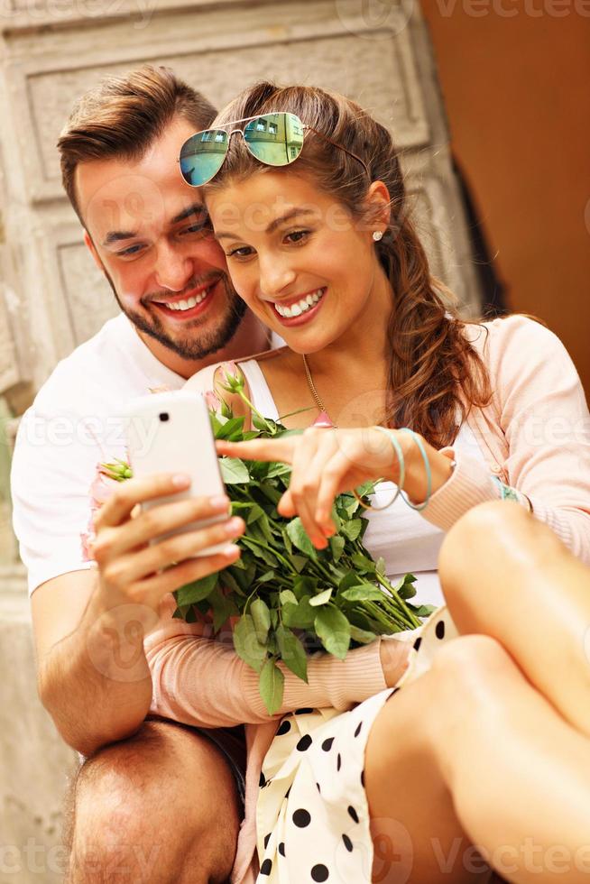 joven pareja romántica con smartphone en la ciudad foto