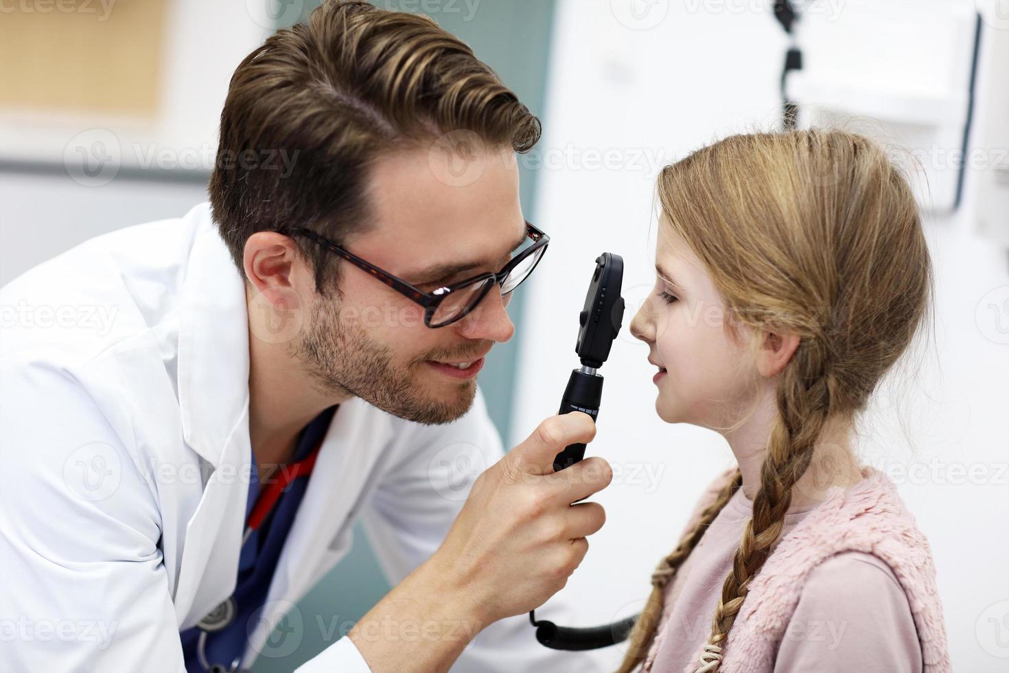 niño, optometrista masculino, examina, vista, de, niña foto