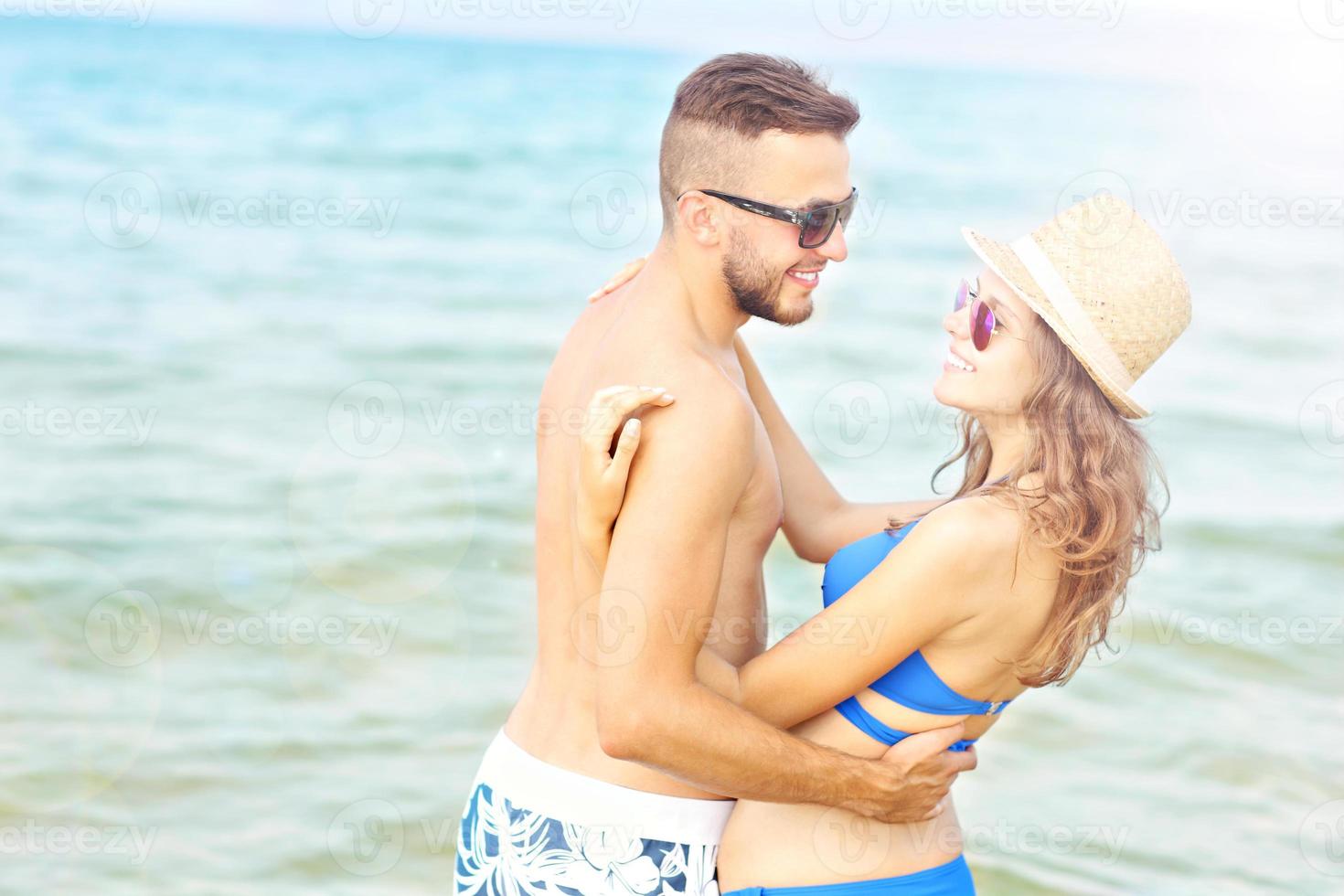 pareja romántica divirtiéndose en la playa foto