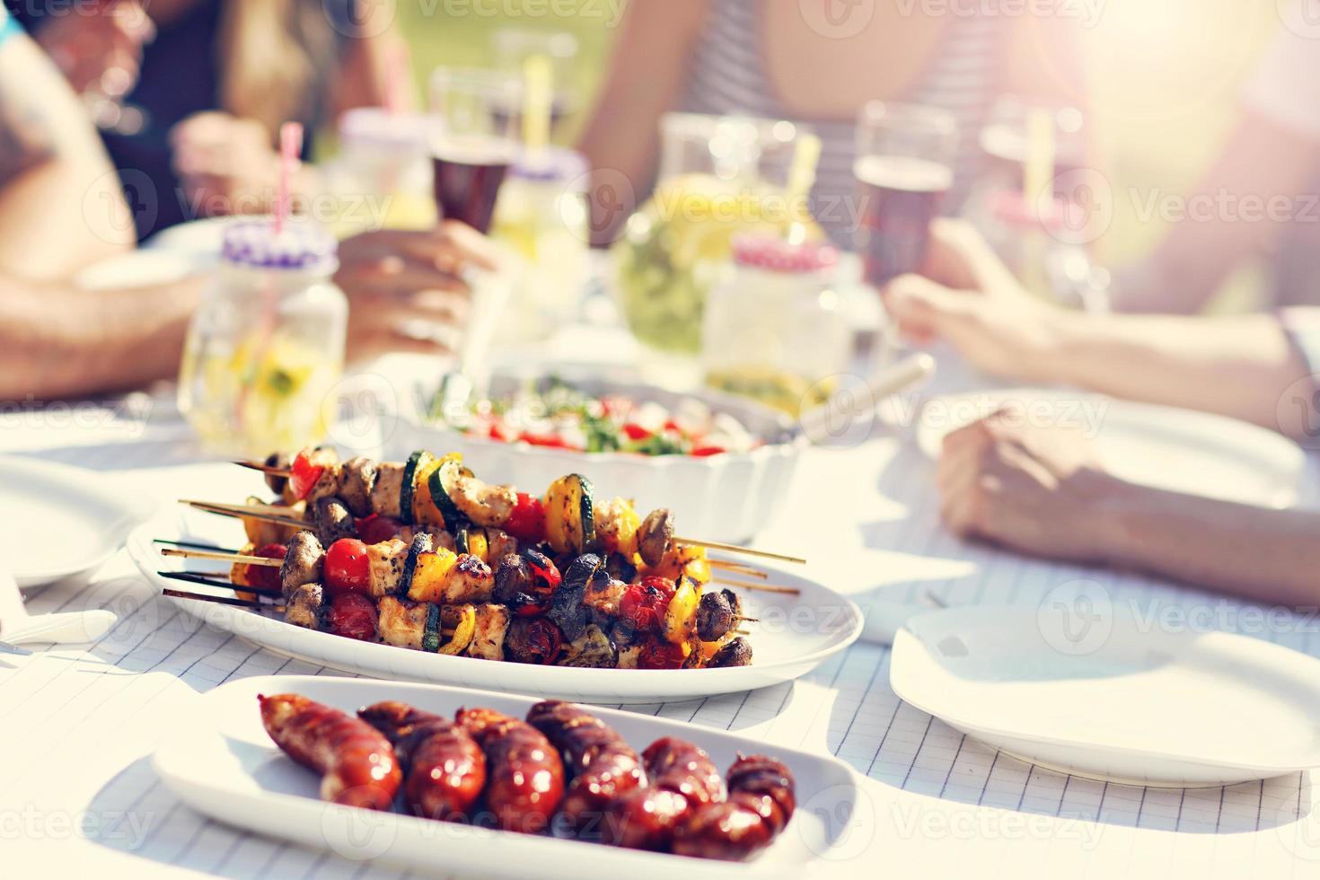 Friends having barbecue party in backyard photo