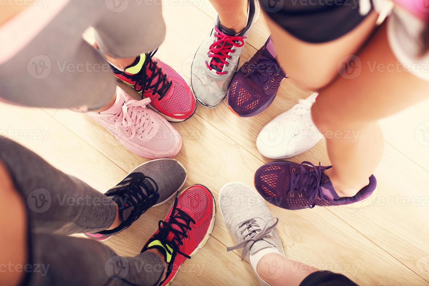 Circle of legs with shoes in a gym photo