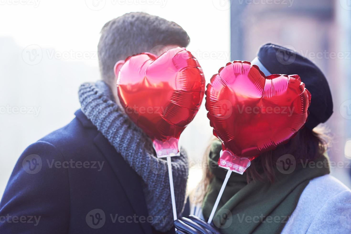 Happy couple celebrating Valentines Day in masks during covid-19 pandemic photo