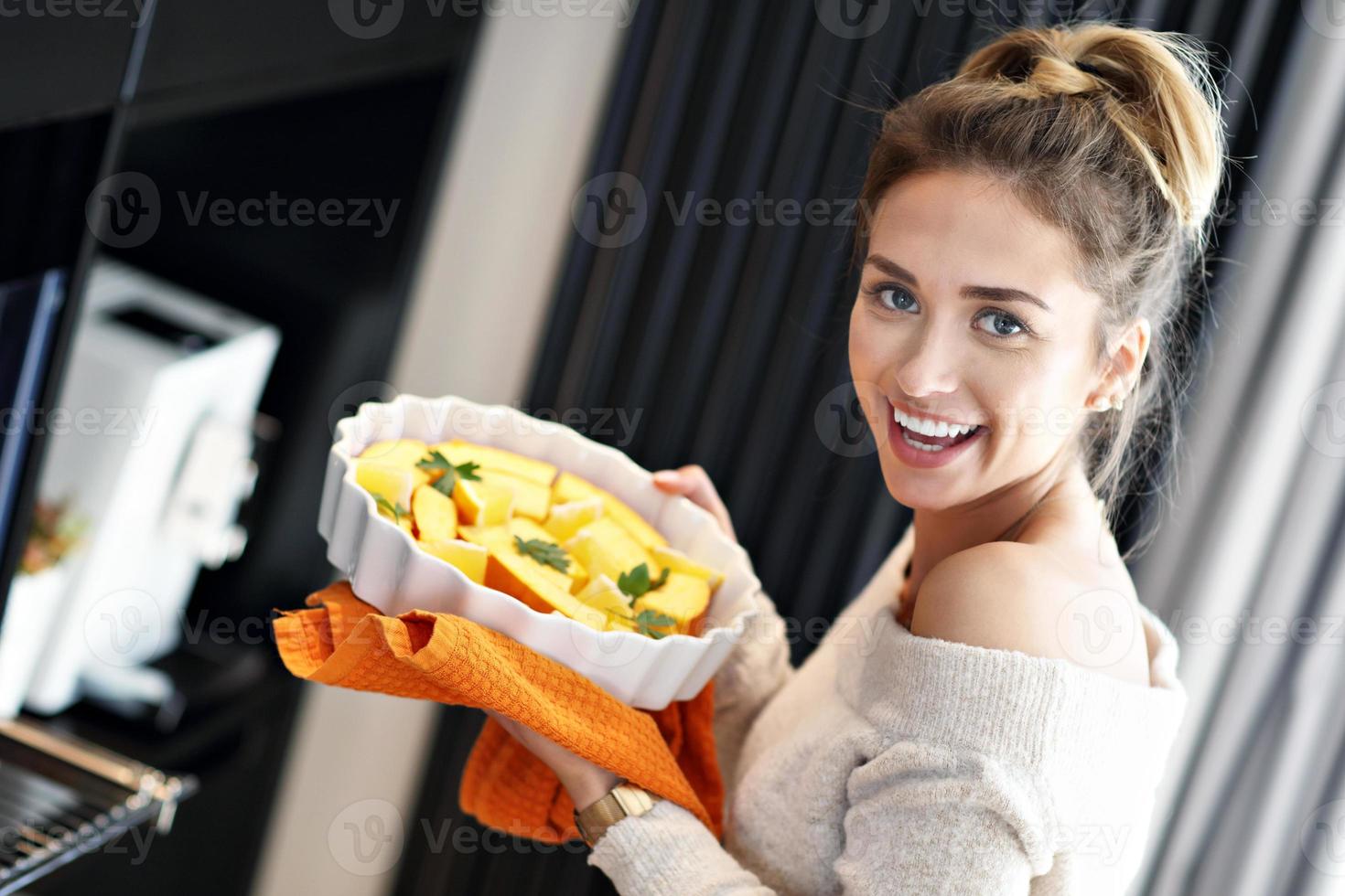 mujer adulta en la cocina preparando platos de calabaza para halloween foto