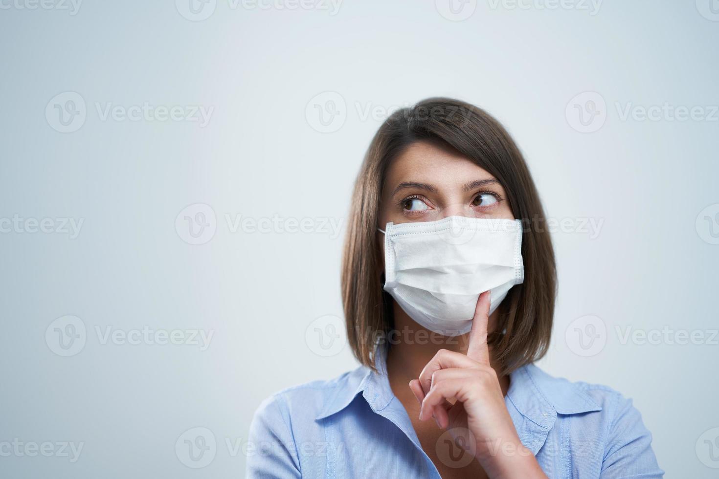 Attractive woman wearing protective mask isolated over white background photo