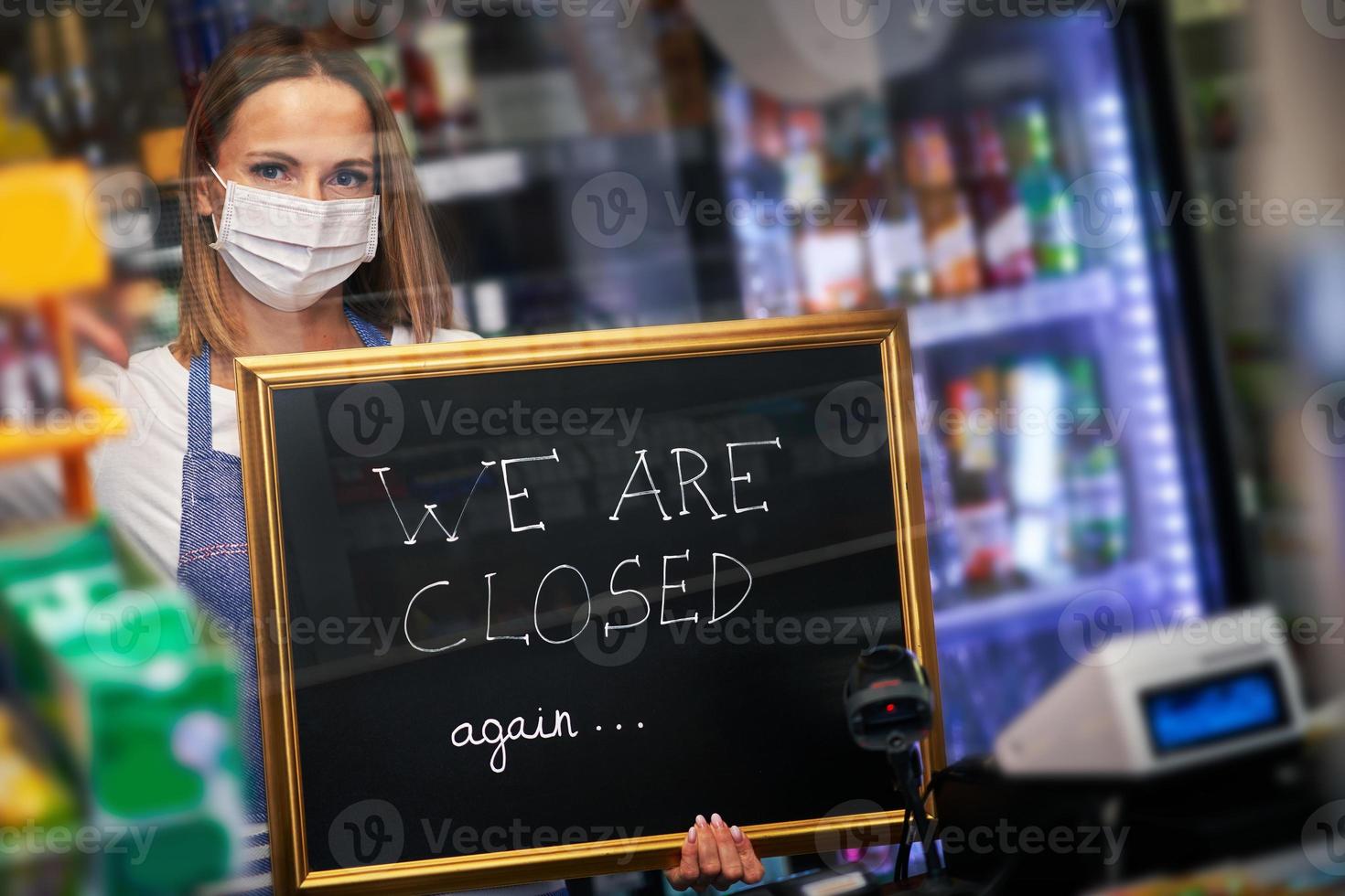 Shop assistant holding announcement board photo