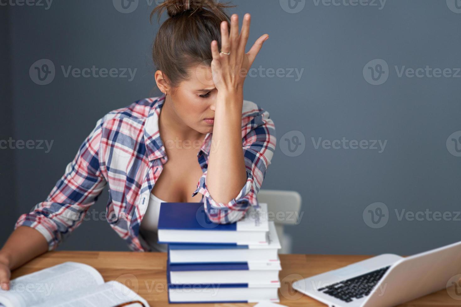 Tired female student learning till late at home photo