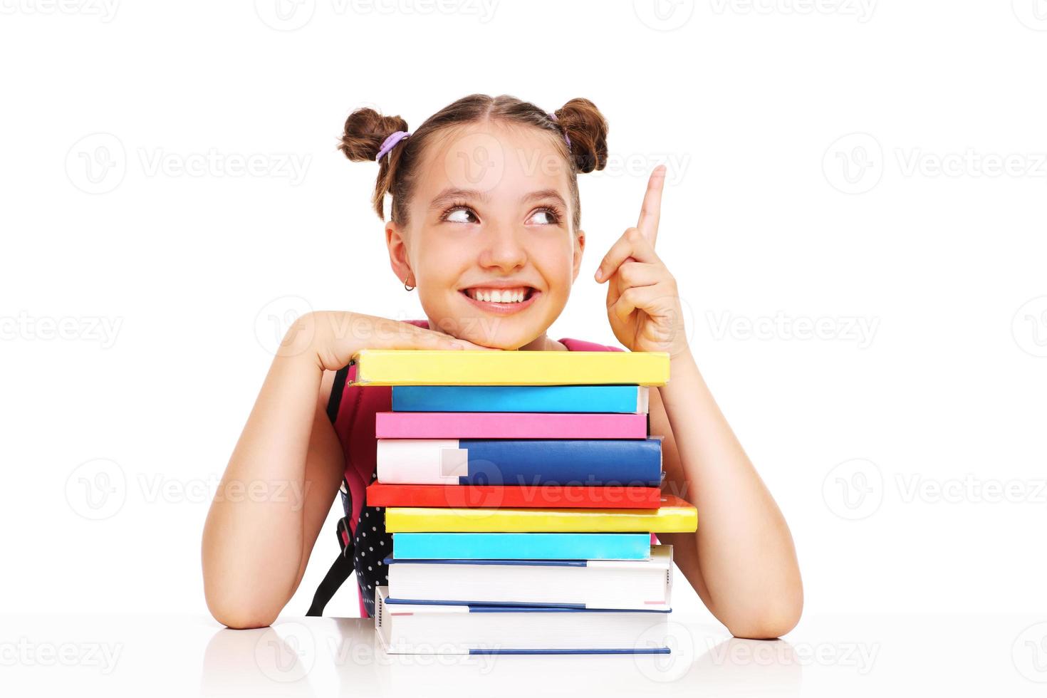 Schoolgirl with books pointing at something photo