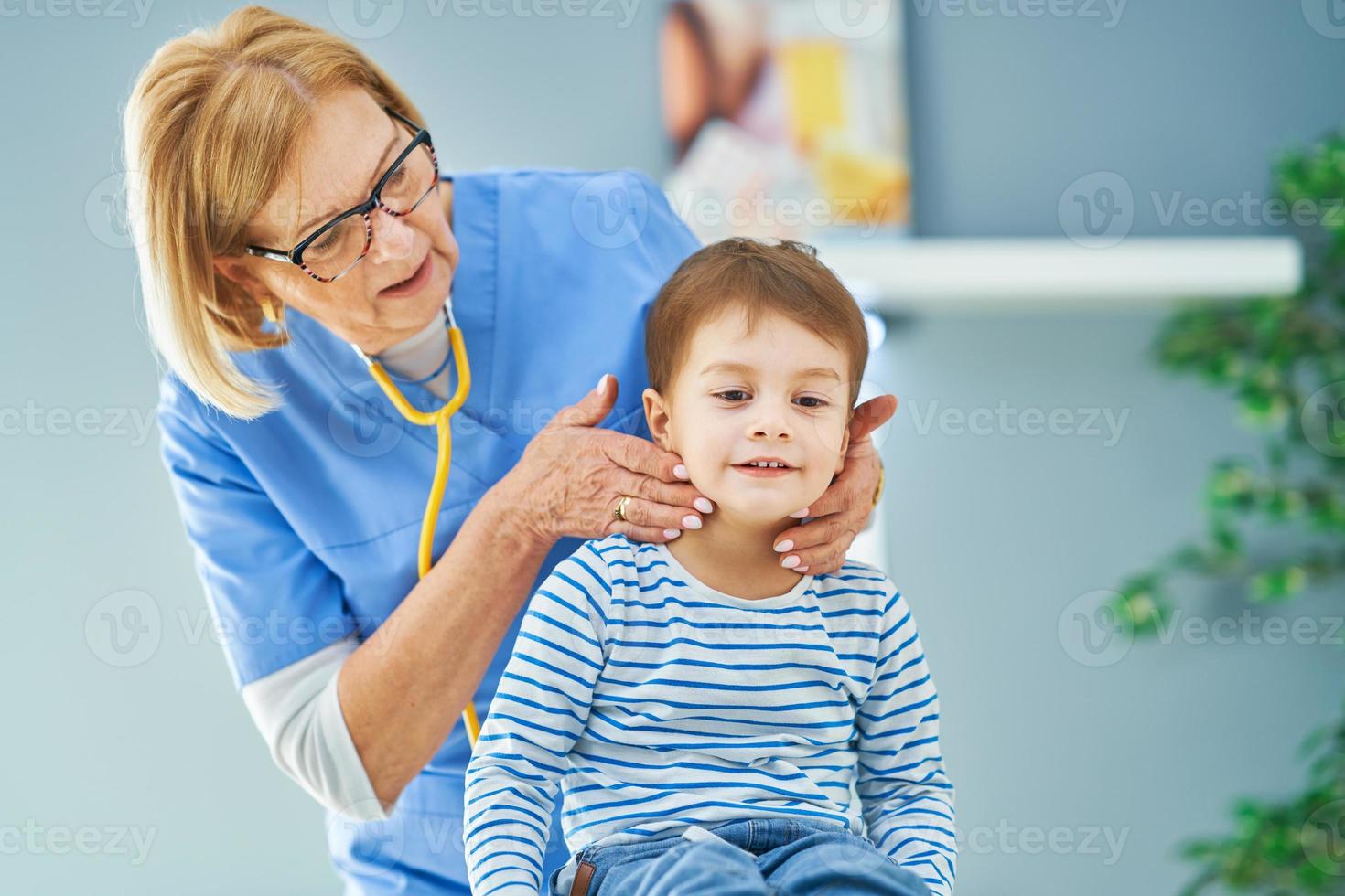 Pediatrician doctor examining little kids in clinic photo