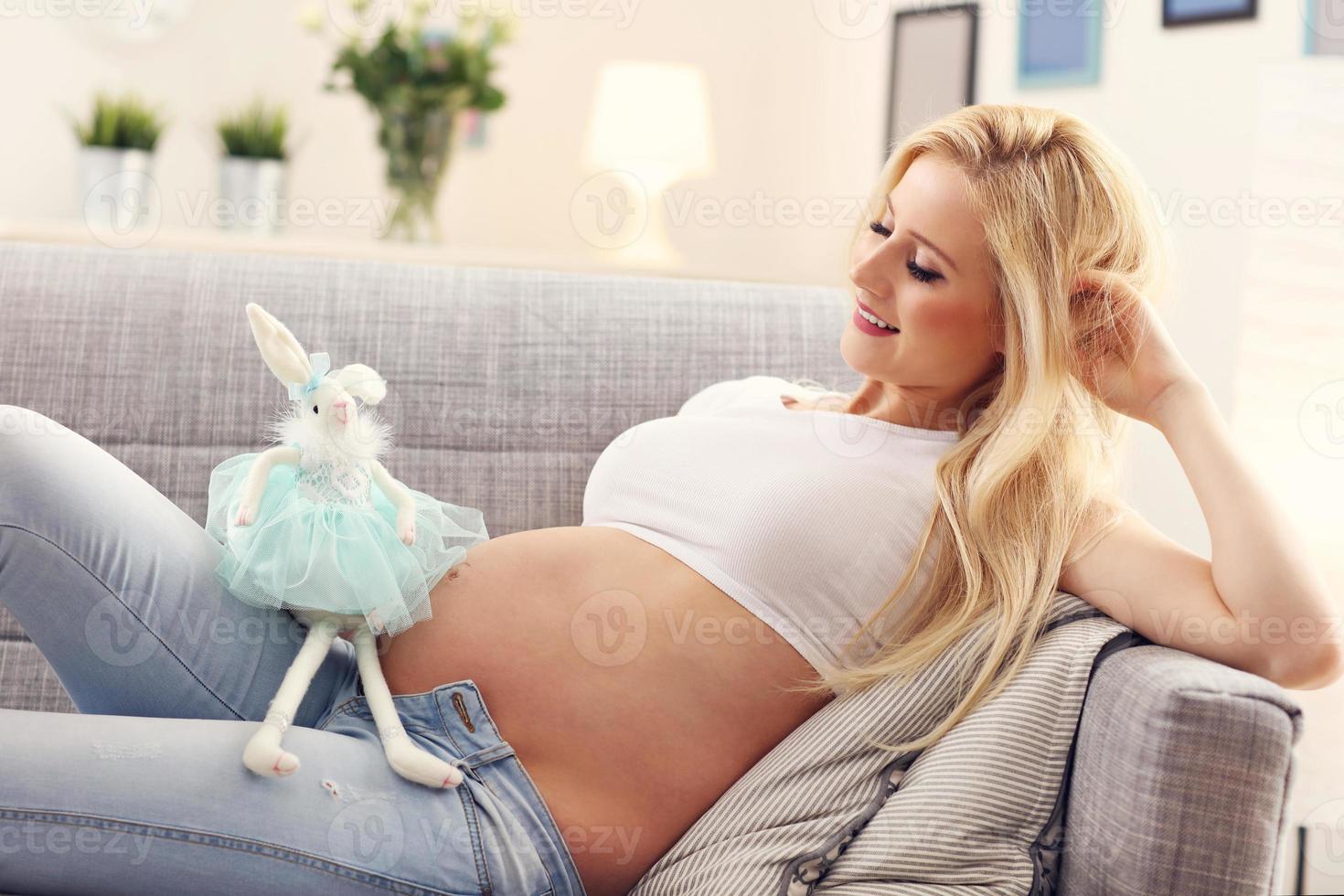 Happy pregnant woman with teddy bear photo