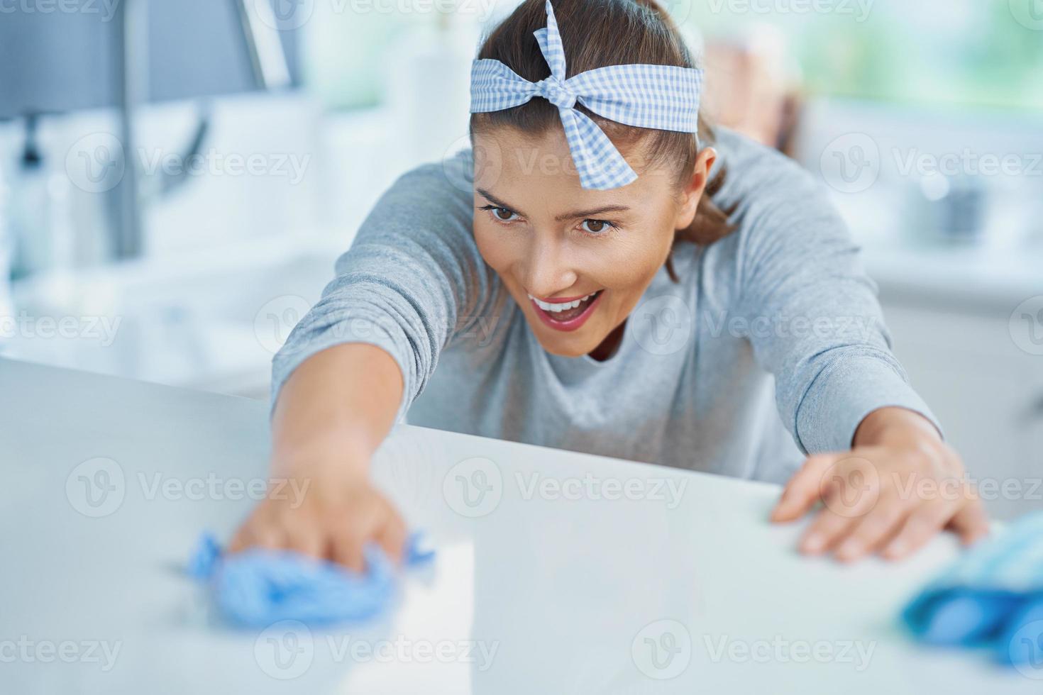 Young woman cleaning dirt in the kitchen photo