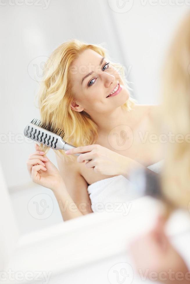mujer joven cepillando el cabello foto