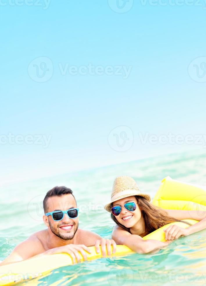 pareja joven divirtiéndose en el mar foto