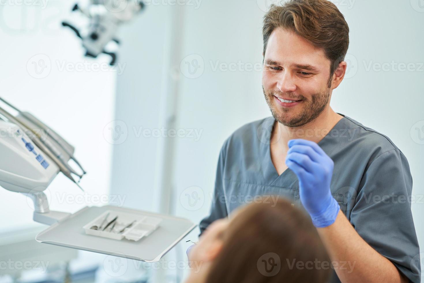 Male dentist and woman in dentist office photo