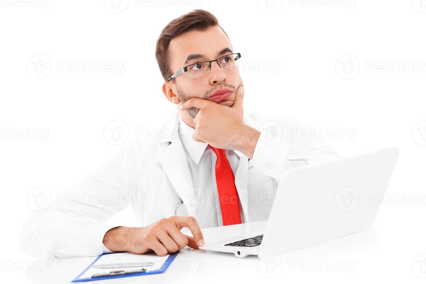 Upset doctor with laptop and documents photo