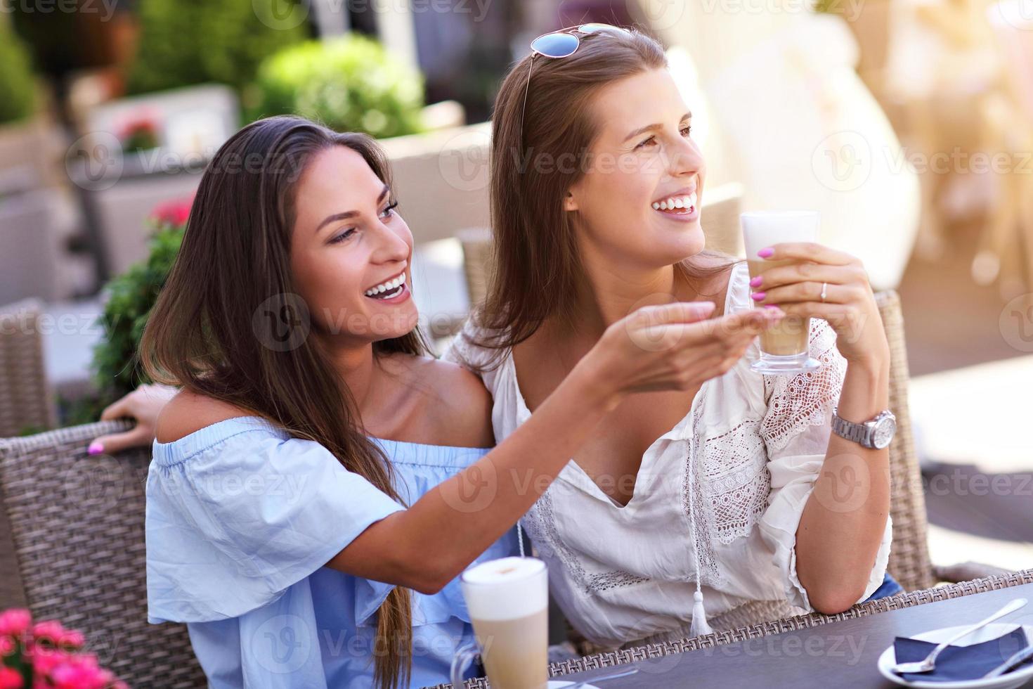 Happy girl friends in cafe during summer time photo