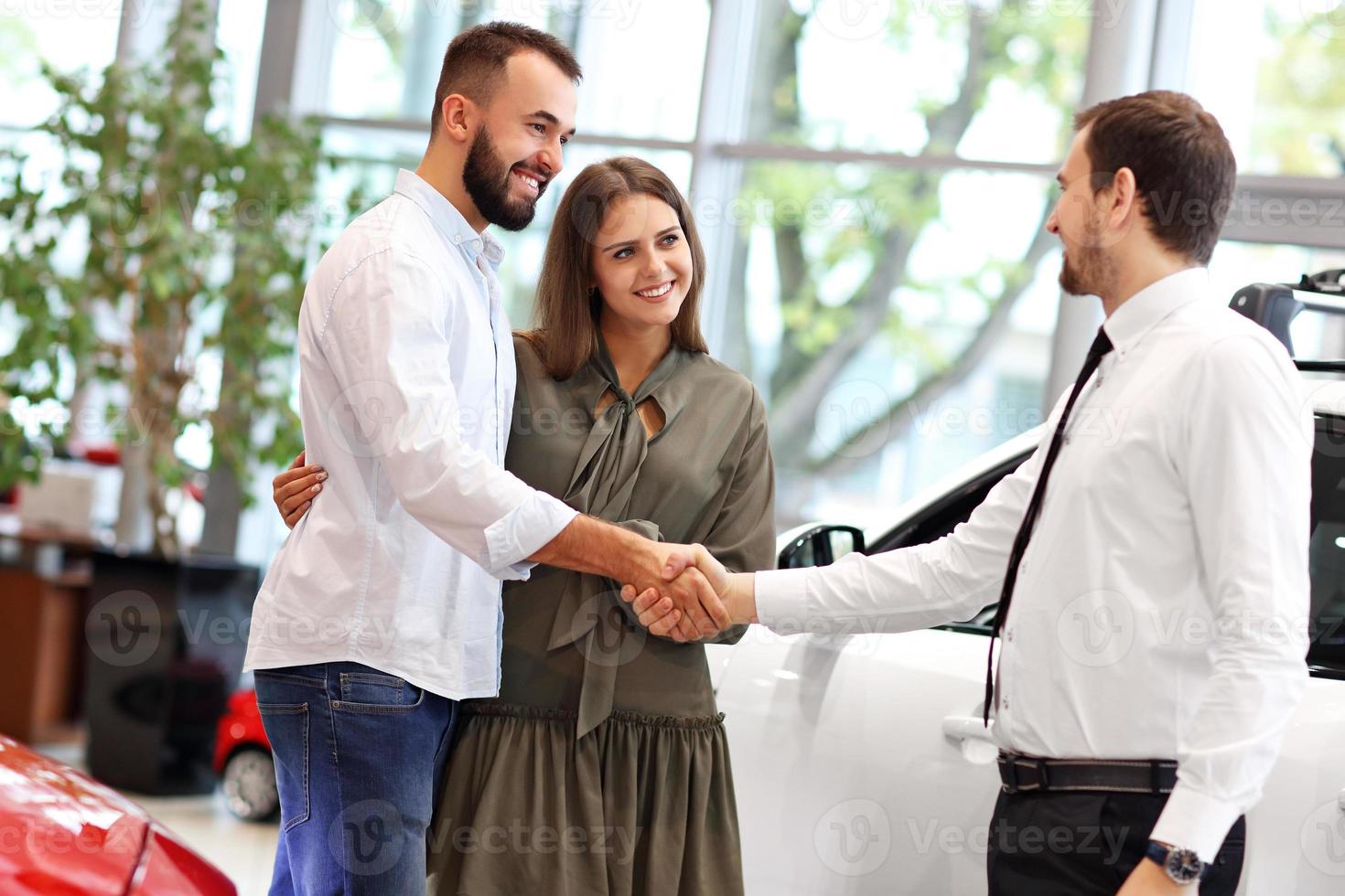 Young couple choosing car in showroom photo