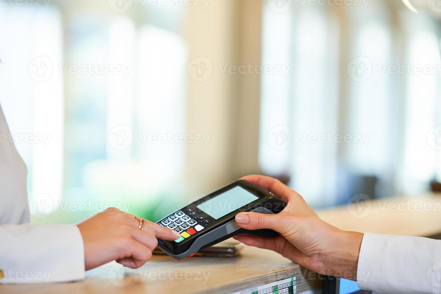 Receptionist and businesswoman at hotel front desk photo