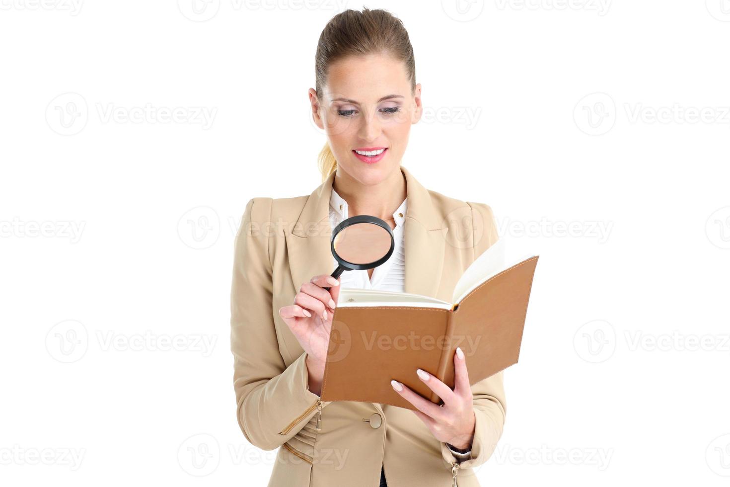 Businesswoman with agenda and magnifying glass photo