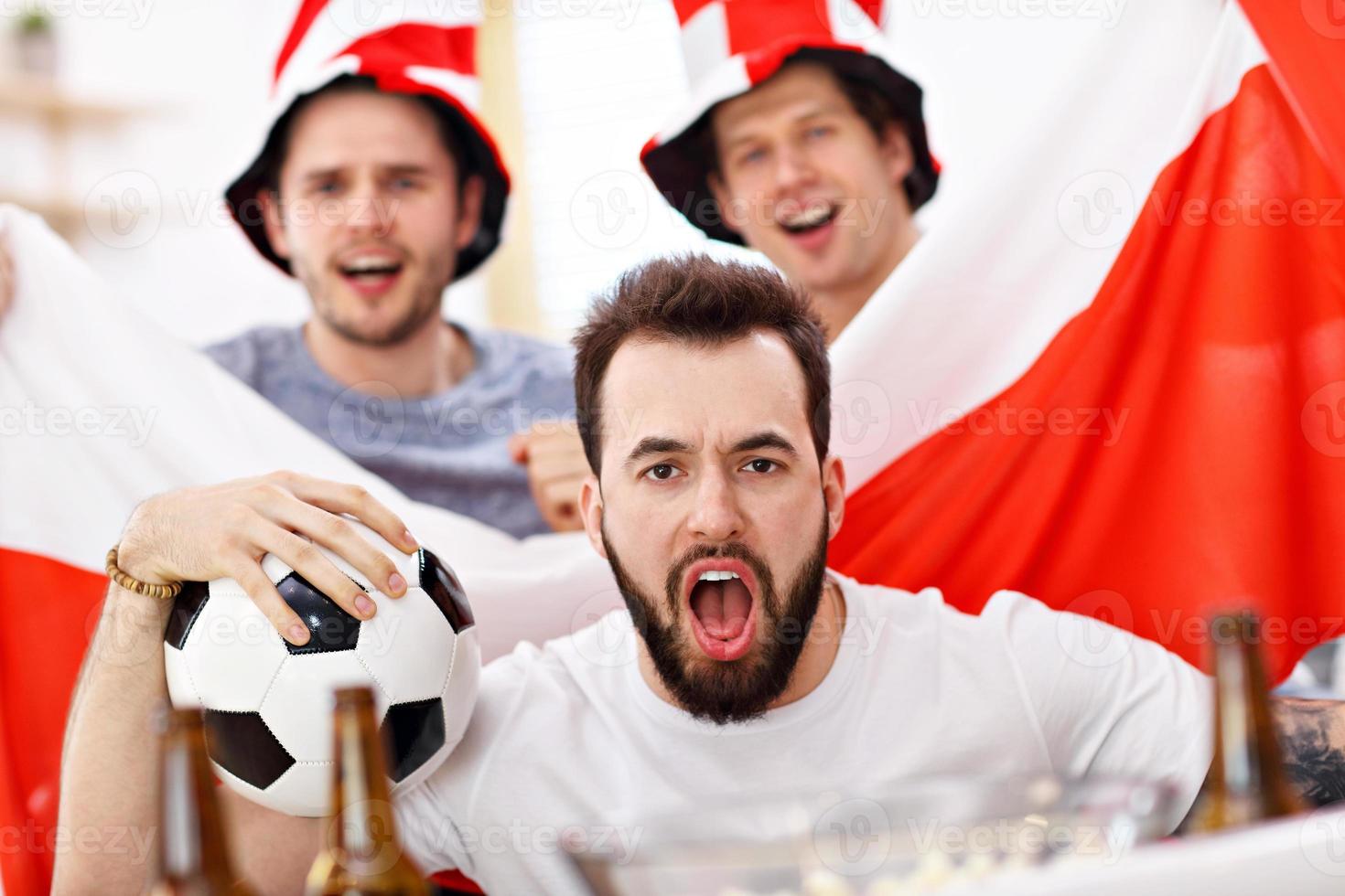 amigos varones felices animando y viendo deportes en la televisión foto