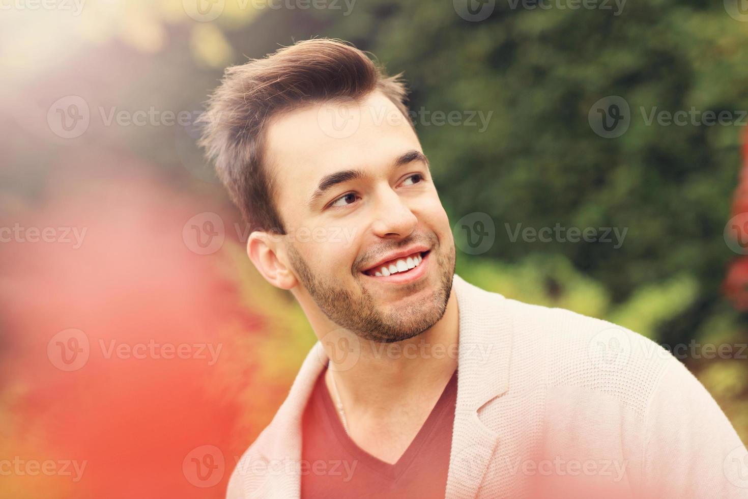 Young happy man in the park in autumn photo