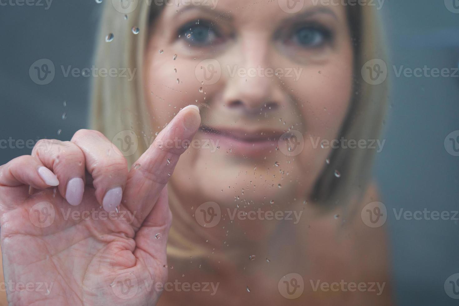 Senior woman taking shower at home photo