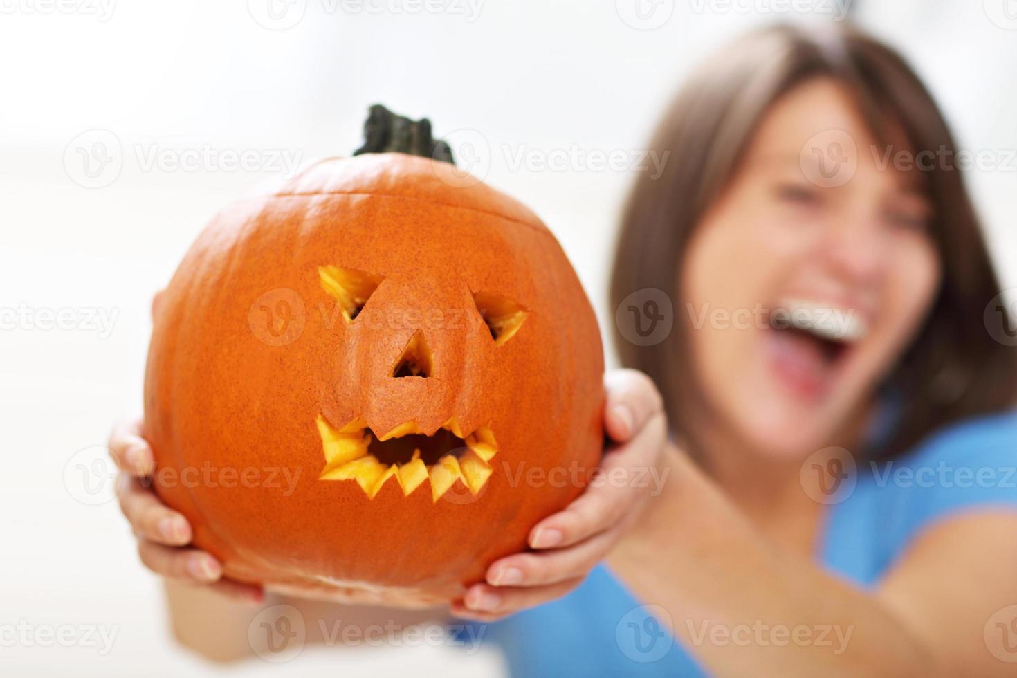 Young woman making jack-o-lantern in the kitchen photo