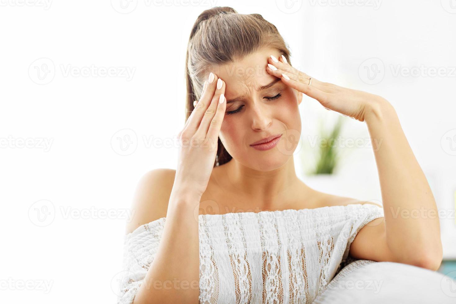 Happy woman suffering from headache at home photo