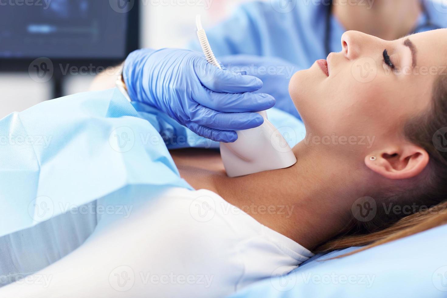 Adult woman having thyroind ultrasound test at female doctor's office photo