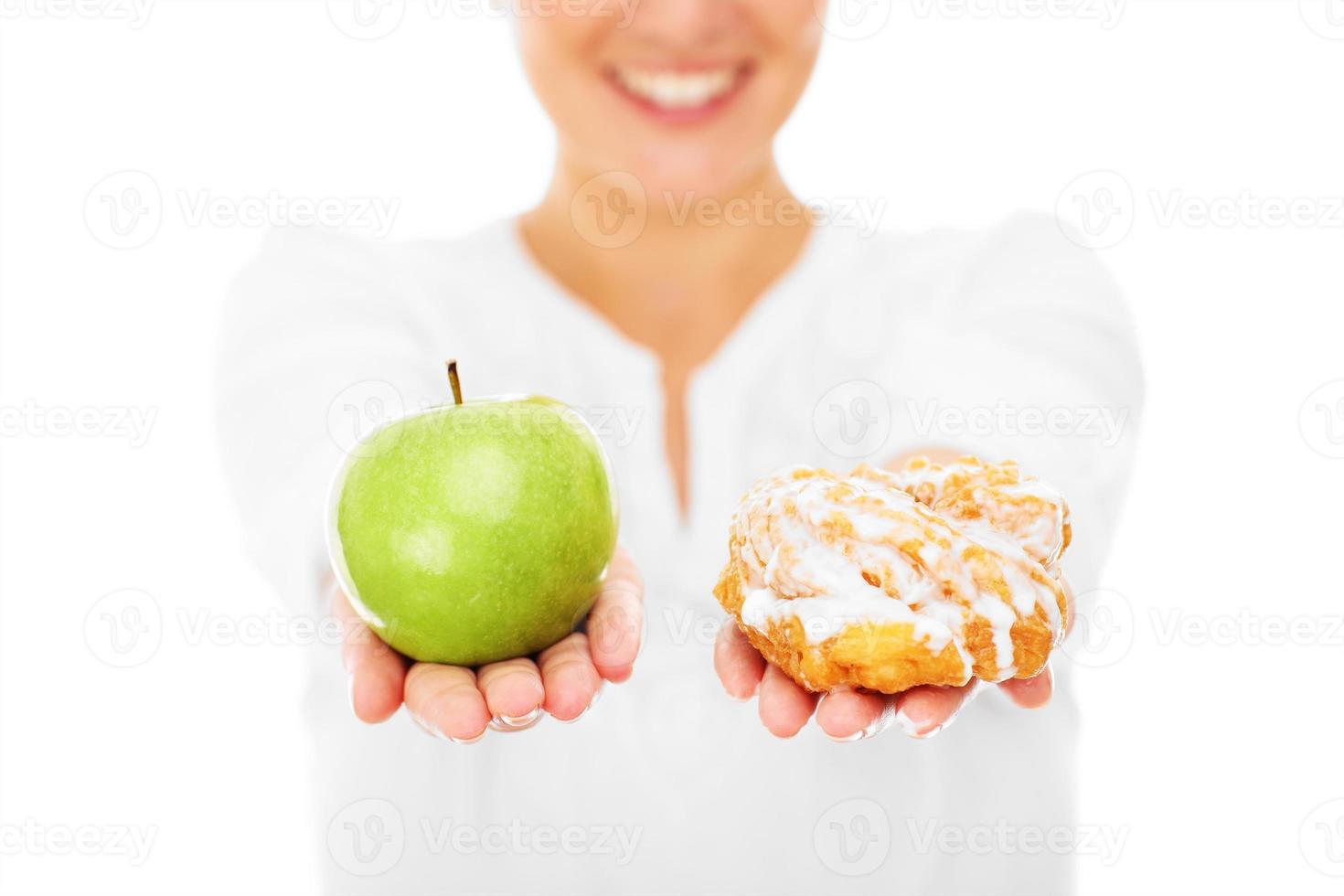 Woman showing apple and donut photo