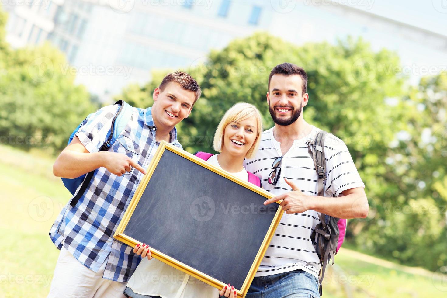 grupo de estudiantes sosteniendo una pizarra en el parque foto