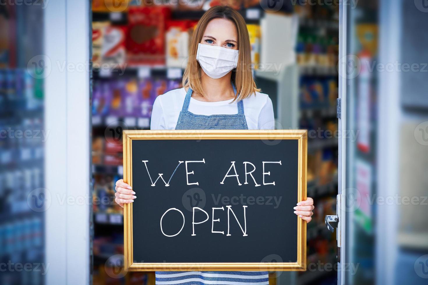 Shop assistant holding announcement board photo