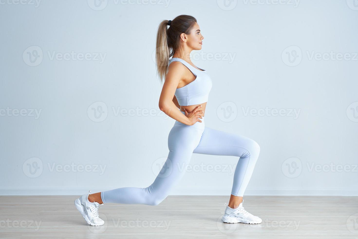 Adult beautiful woman working out over light background photo